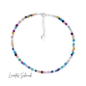 May include: A colorful beaded necklace with a silver heart charm and clasp. The beads are in shades of pink, blue, green, yellow, and purple.