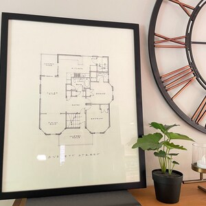 Puede incluir: Impresión enmarcada en negro de un plano de planta con el texto "Everett Street" en la parte inferior. El plano de planta muestra una sala de estar, una cocina, un baño y un dormitorio.
