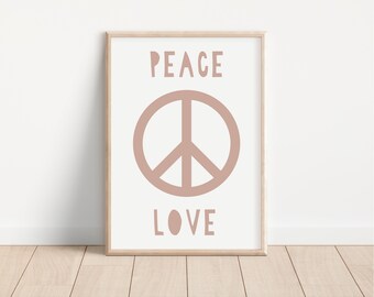 Op de afbeelding: Een ingelijste print met de woorden "PEACE" en "LOVE" in een zachte bruine kleur. Een vredesteken is gecentreerd onder het woord "PEACE". Het kunstwerk zit in een lichte houten lijst.