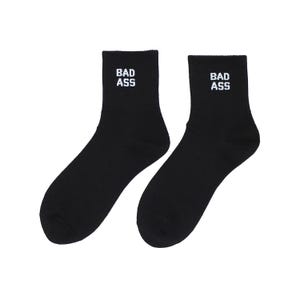 May include: A pair of black crew socks with the words "BAD ASS" in white block letters near the top. The socks are made of a soft, ribbed material and are designed to be worn on the feet.