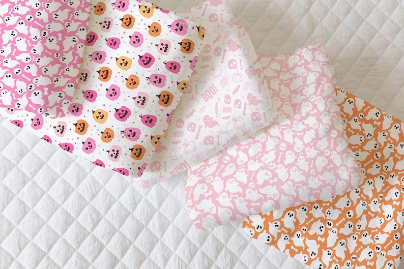 May include: Four different fabric swatches with Halloween-themed patterns. The patterns include pink ghosts, orange pumpkins, and the words "Boo!" in pink. The fabrics are all white with pink and orange accents.