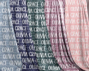 May include: Four fleece blankets with a white script pattern of the names "Olivia" and "Grace" on a blue, navy, teal, and pink background.