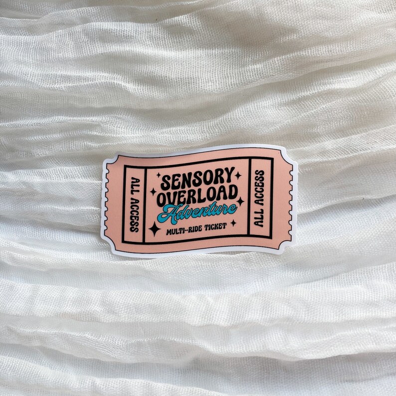 May include: Pink ticket sticker with the text "Sensory Overload Adventure" and "Multi-Ride Ticket" in blue and white text. The sticker has "All Access" written on both sides.
