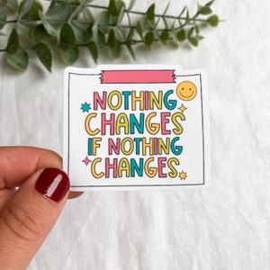Puede incluir: Pegatina blanca con un diseño rosa, amarillo, azul y verde. La pegatina dice "Nada cambia si nada cambia" con una cara sonriente y estrellas.