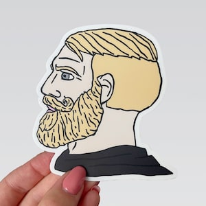 May include: A sticker of a man's face with a beard and blonde hair. The man is looking to the left and has a serious expression. The sticker is on a white background.