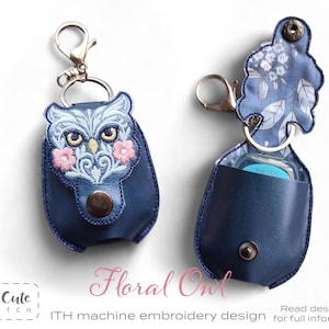 May include: Two navy blue keychains with a floral owl design. One keychain is closed, and the other is open, revealing a small bottle. The owl design features pink flowers and intricate embroidery. The text "Floral Owl" and "So Cute Stitch" are visible.