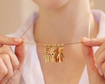 May include: Gold necklace with multiple charms in the shape of children. Each charm has a name engraved on it: "Braydyn", "Brayden", and "Brayden".