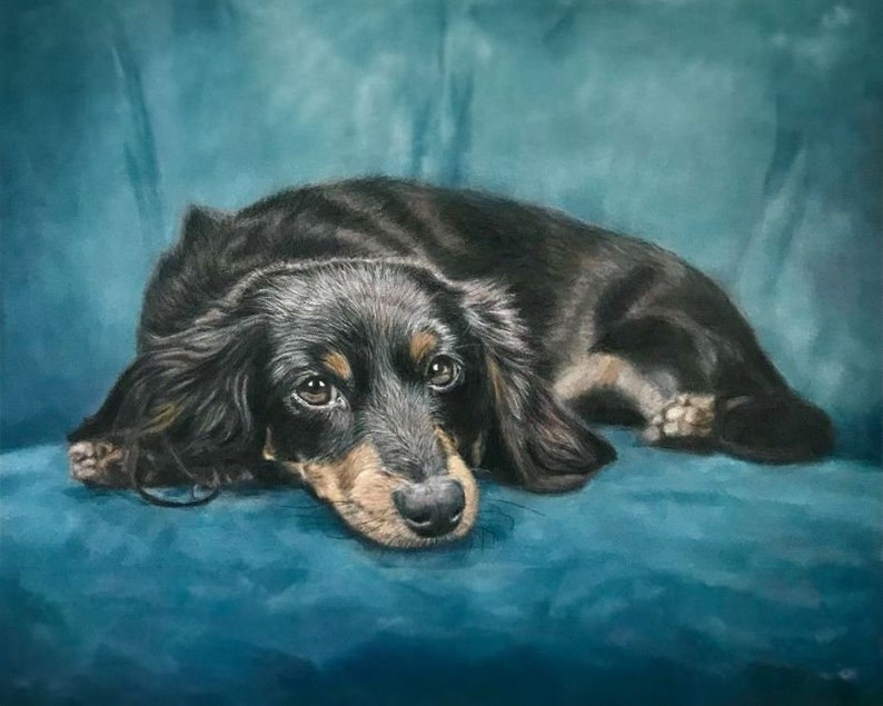Puede incluir: Pintura detallada de un perro salchicha de pelo largo tumbado sobre una superficie azul verdoso. El perro tiene pelaje negro con marcas marrones alrededor de la cara y las patas. Los ojos del perro est&aacute;n abiertos y parece estar mirando al espectador.