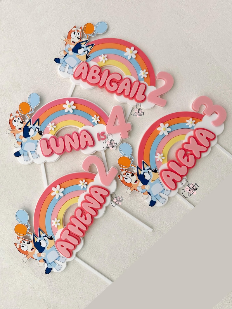 Pu&ograve; includere: Quattro topper per torta a forma di arcobaleno colorati con i nomi Abigail, Luna, Athena e Alexa, ognuno con un numero e un cane dei cartoni animati.