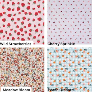 May include: Four fabric swatches with different patterns. The top left shows red strawberries on a pink background, labeled "Wild Strawberries." The top right has red cherries on a white background, labeled "Cherry Sprinkle." The bottom left features a floral pattern, labeled "Meadow Bloom." The bottom right shows peaches on a checkered background, labeled "Peach Orchard."