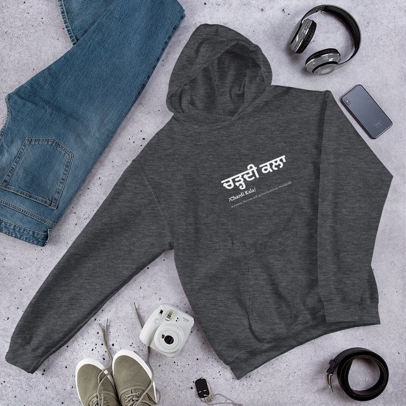 May include: A dark gray hooded sweatshirt with the text "Chardi Kala" in white lettering. The text is in Punjabi and translates to "Eternal Optimism".