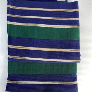 May include: A folded fabric with alternating stripes of navy blue, gold, and green. The fabric is woven with a textured pattern.