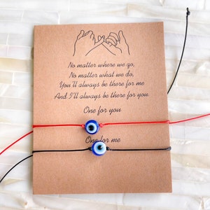 Puede incluir: Dos pulseras de amistad con dijes azules de ojo turco. Las pulseras son de hilo rojo y negro. La tarjeta dice: "No importa a dónde vayamos, No importa lo que hagamos, Siempre estarás ahí para mí Y siempre estaré ahí para ti. Uno para ti Uno para mí"