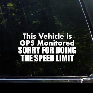 May include: A white sticker on a black car window that reads "This Vehicle is GPS Monitored Sorry for Doing the Speed Limit".