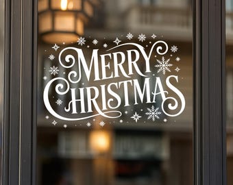 May include: White "Merry Christmas" decal with snowflake accents, applied to a glass door. The text is in a decorative script font. The background shows a blurred interior with a warm light.