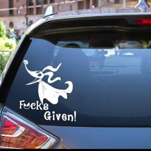 Puede incluir: Una pegatina de coche de vinilo blanco con un personaje de dibujos animados de la película "Pesadilla antes de Navidad" con el texto "F**k's Given!"