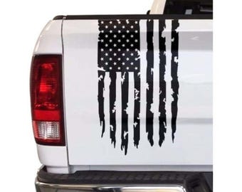 May include: A black and white distressed American flag decal on the back of a white pickup truck.