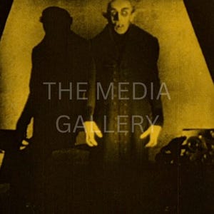 May include: A black and white image of a man in a long coat with a pale face and dark eyes. He is standing in a dimly lit room with a shadow behind him. The image is from a classic horror film.
