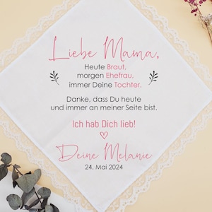 Può includere: Fazzoletto di pizzo bianco con un messaggio rosa che dice "Liebe Mama, Heute Braut, morgen Ehefrau, immer Deine Tochter. Danke, dass Du heute und immer an meiner Seite bist. Ich hab Dich lieb! Deine Melanie 24. Mai 2024"
