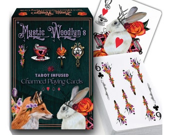 May include: A deck of tarot-infused playing cards with a green background and a fox and rabbit design. The box features the text "Mystic Woodlyn's Tarot Infused Charmed Playing Cards".