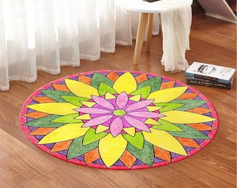 May include: A round, colorful mandala rug with a pink flower in the center. The rug has a red border and is made of a soft, plush material.