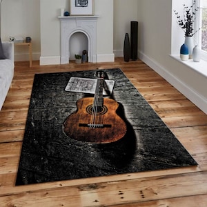 May include: A brown acoustic guitar with a sheet of music on a dark gray woodgrain rug.