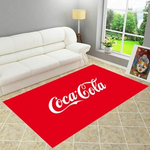 Puede incluir: Alfombra roja con el logotipo de Coca-Cola en letras blancas.