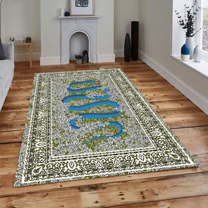 May include: A white rug with a blue snake design on a green background. The snake is surrounded by white flowers. The rug has a black and white border.