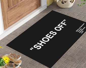 May include: Black doormat with white text that reads "Shoes Off" and a small copyright notice at the bottom right corner.