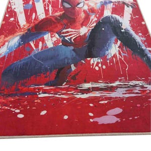 Puede incluir: Un personaje de Spiderman rojo y azul con un dise&ntilde;o de telara&ntilde;a blanca sobre un fondo rojo con salpicaduras de pintura blanca. La imagen tiene la palabra "SAMPLE" en la esquina superior derecha.