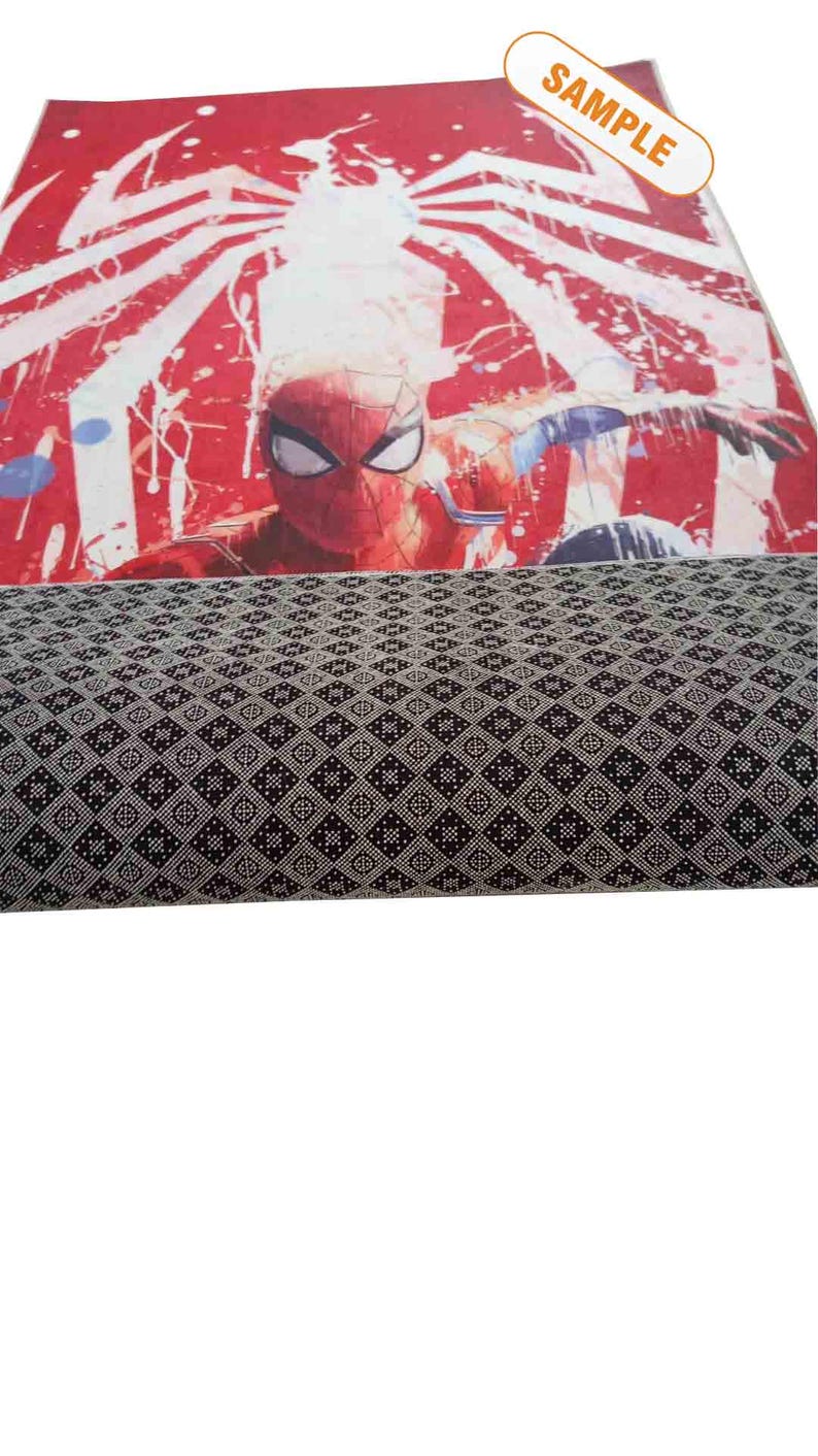Puede incluir: Alfombra roja y blanca con un gr&aacute;fico de Spiderman y una telara&ntilde;a. La alfombra tiene un patr&oacute;n geom&eacute;trico blanco y negro en la parte inferior.