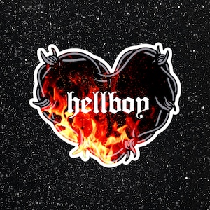 May include: A black and white heart-shaped graphic with barbed wire around the edges. The heart is filled with flames and the word "hellboy" is written in a gothic font.