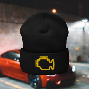 May include: Black beanie with a yellow check engine light icon embroidered on the front.