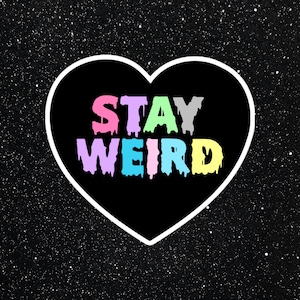 Peut inclure: Un graphique en forme de cœur noir avec un contour blanc sur un fond noir avec des points blancs. Le graphique dit "STAY WEIRD" en lettres arc-en-ciel qui coulent.