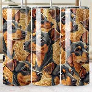 May include: A stainless steel tumbler featuring a repeating pattern of dogs with black, brown, and tan fur. The dogs' faces are the primary focus, set against a textured, golden-brown background. The tumbler has a silver straw.