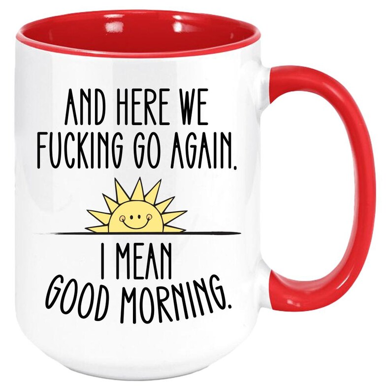Pode incluir: Caneca de caf&eacute; branca com borda e al&ccedil;a vermelhas. A caneca tem texto preto que diz "And here we fucking go again. I mean good morning." com um sol amarelo com um rosto sorridente acima do texto.