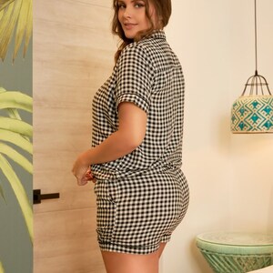 May include: A black and white gingham pyjama set with short sleeves and shorts. The set is made from a soft, comfortable fabric.