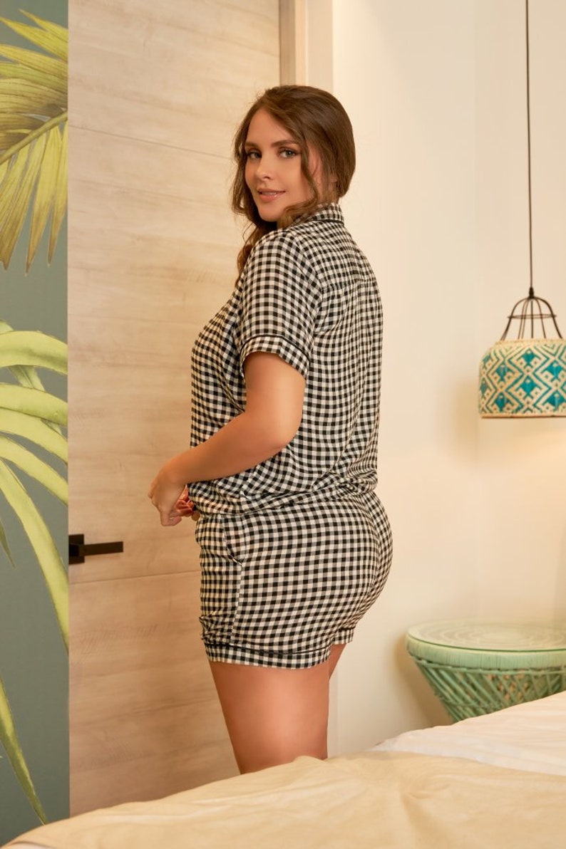 May include: A black and white gingham pyjama set with short sleeves and shorts. The set is made from a soft, comfortable fabric.