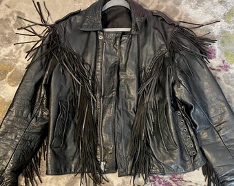 May include: A black leather jacket with fringe detailing. The jacket has a zipper closure and a stand-up collar.