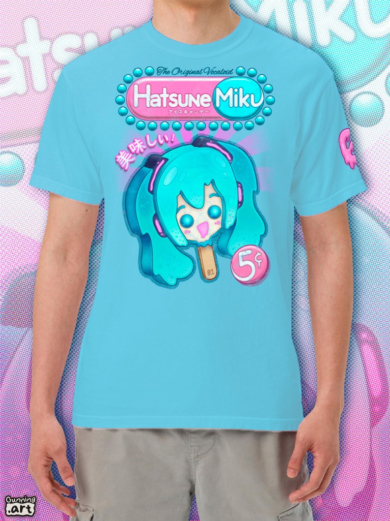 Op de afbeelding: Lichtblauw T-shirt met een cartoon illustratie van Hatsune Miku als ijslolly. Het ontwerp bevat de tekst "Hatsune Miku" en Japanse karakters. De ijslolly heeft blauw haar en zit op een houten stokje. De prijs is "5&cent;".