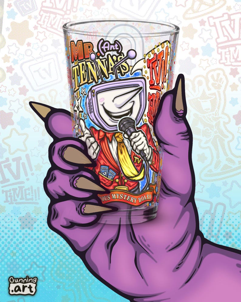 May include: A clear glass with a cartoon illustration of a TV-headed character holding a microphone. The character is wearing a red suit and yellow tie. The glass is held by a purple hand with long claws. Text on the glass reads "Mr. Antenna" and "Famous Mystery Board".
