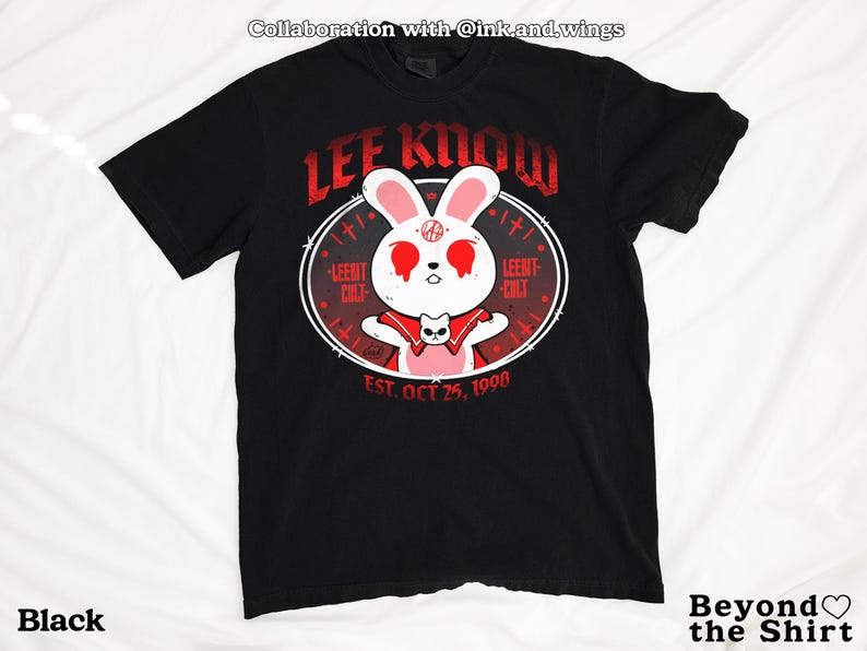 May include: Black t-shirt featuring a white rabbit with red eyes and a red cape, surrounded by a circular design with the text "LEE KNOW" and "LEEMT CULT". The shirt also includes the text "EST. OCT 25, 1998".