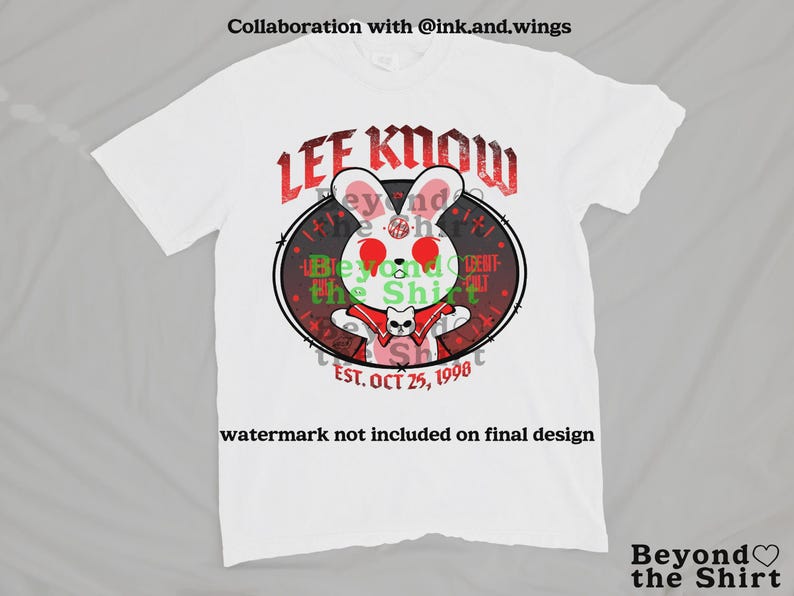 May include: White t-shirt featuring a cartoon rabbit with red eyes and a red cape, encircled by a black oval with the text "LEE KNOW" in red. The shirt also includes the text "EST. OCT 25, 1998" and "Beyond the Shirt".