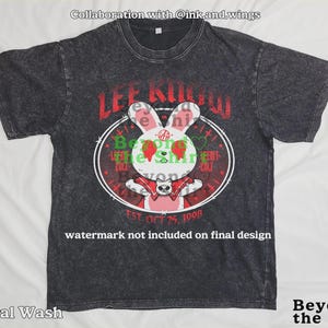 May include: Dark gray mineral wash t-shirt featuring a cartoon rabbit design with the text "LEE KNOW" in red. The rabbit has strawberry eyes and a red bow tie. The shirt also includes the text "EST. OCT 25, 1998".