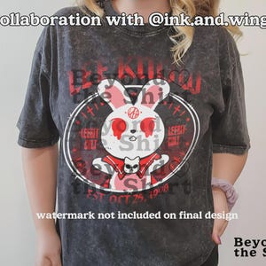 May include: Dark gray t-shirt featuring a white rabbit with red eyes and a cat graphic. The shirt has the text "Be Kind" and "LeeBit Shi" in red. The shirt also has the text "EST OCT 25, 1998".