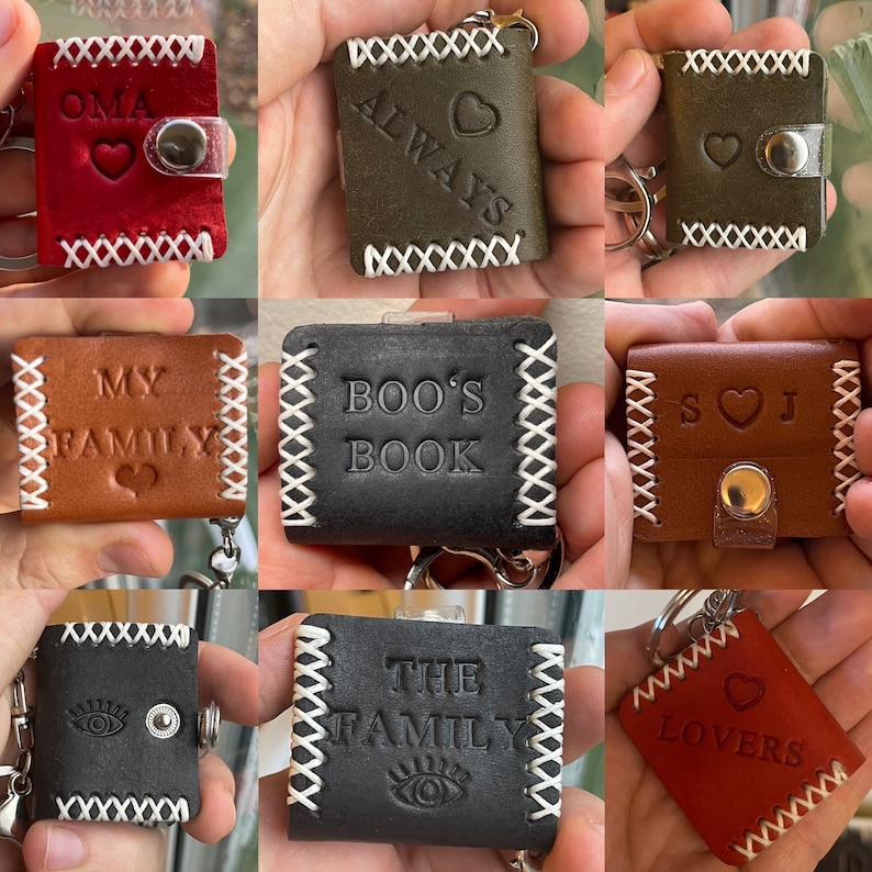 May include: Nine different leather keychains with various designs and text. The keychains are all small, square, and have a white stitched border. The text on the keychains includes "OMA", "ALWAYS", "MY FAMILY", "BOO'S BOOK", "S J", "THE FAMILY", and "LOVERS".