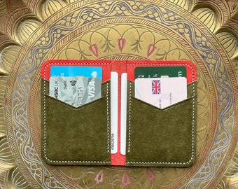 May include: A green leather wallet with red stitching and two card slots. The wallet has a white stitching detail around the edges and a white label with the number 430329705. The wallet is open and shows two cards inside, one with the HSBC UK logo and the other with the VISA logo.