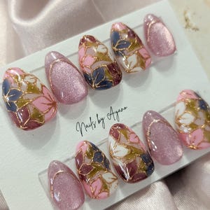 Uñas pintadas a mano con motivos florales, cromados, de ojo de gato y prensa francesa.