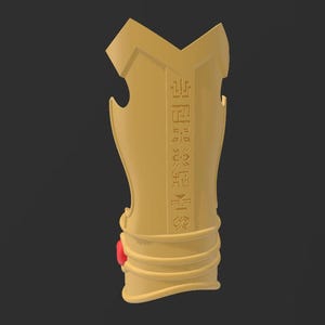May include: A golden-colored arm guard with engraved symbols and a red gem. The arm guard has a curved shape with a series of horizontal lines near the bottom. The background is a solid dark gray.