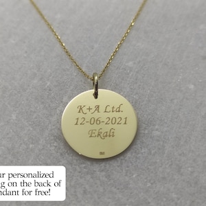 May include: Gold pendant necklace with a round disc charm engraved with the text "K+A Ltd. 12-06-2021 Ekali".